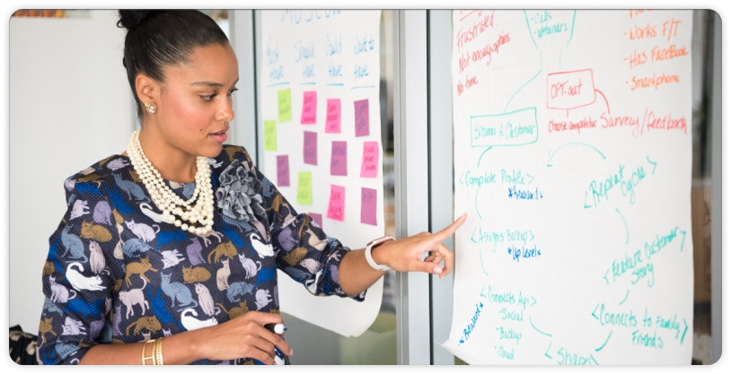 women explaining something on the white paper